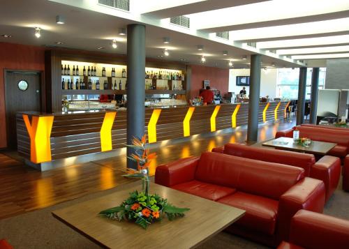 a restaurant with red chairs and a bar with yellow accents at Hausboaty Ypsilon Golf Liberec in Fojtka