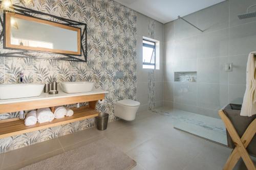 a bathroom with a toilet and a sink and a shower at Waterfalls Lodge in Victoria Falls