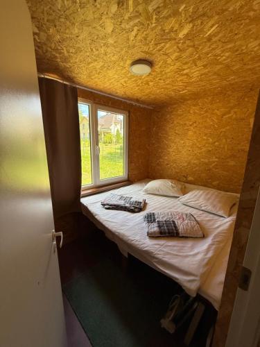 a bed in a room with two pillows and a window at Razna Lake House in Astici