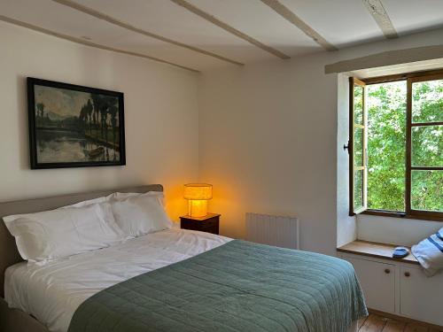 a bedroom with a bed and a window at La Maison des Sources in Édon