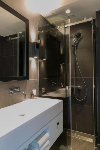 a bathroom with a sink and a shower at B-aparthotel Kennedy in The Hague