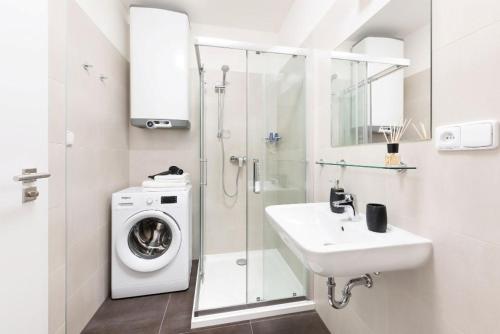 a bathroom with a washing machine and a sink at Prague Roof Apartments in Prague
