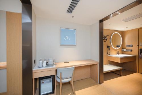 a bathroom with a desk and a sink and a mirror at JI Hotel Beijing Panjiayuan in Beijing
