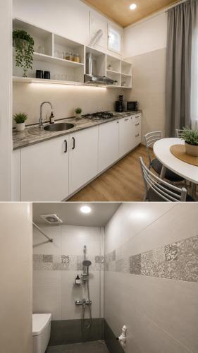 a kitchen with white cabinets and a sink and a table at BakuDowntownHostel in Baku