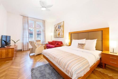 a bedroom with a large bed and a living room at Prague Roof Apartments in Prague
