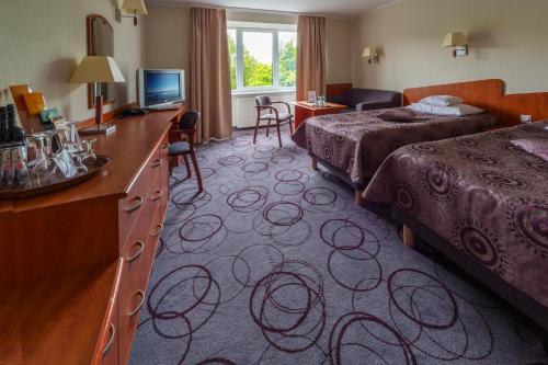 a hotel room with two beds and a television at Hotel Lidia - część Economy in Darłowo