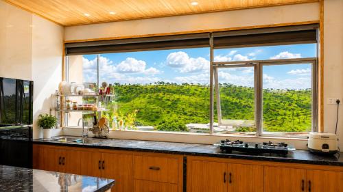 a kitchen with a large window with a view at LaLa Hill in Ấp Kim Thạch