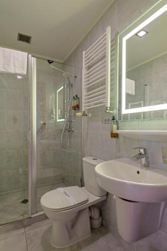 a bathroom with a toilet and a sink and a shower at Hotel Lidia - część Economy in Darłowo