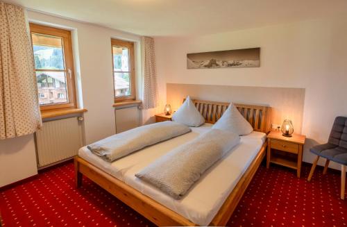 a bedroom with a bed with two pillows on it at Appartement Doris in Schröcken