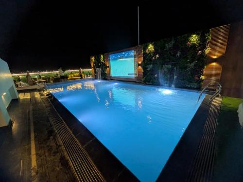 a large swimming pool lit up at night at Red Fox by Lemon Tree Hotels, Alwar in Alwar