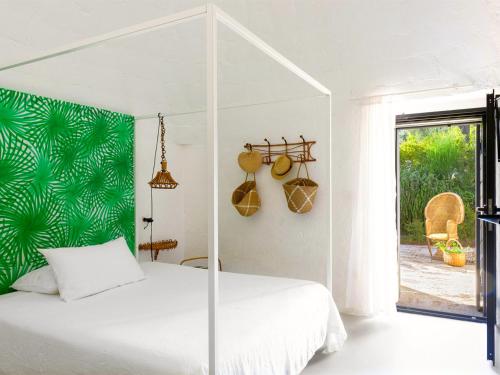 a bedroom with a white bed with a green wall at Cocotrullo in Ostuni