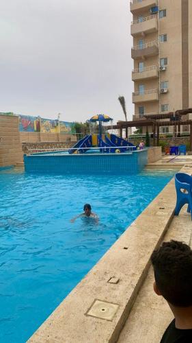 a person swimming in a swimming pool in a resort at Biu Bela abartment hotel 2 in El Alamein