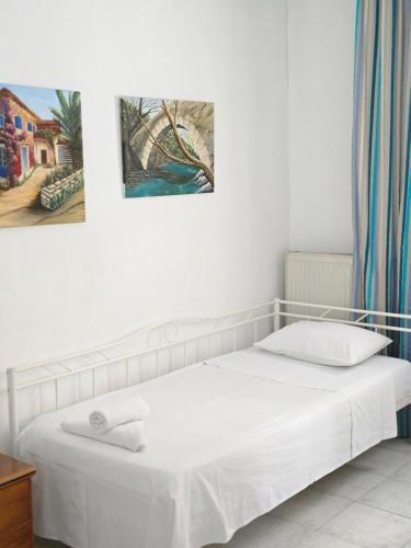 a bed in a room with two paintings on the wall at Anna-Maria in Nea Kallikrateia
