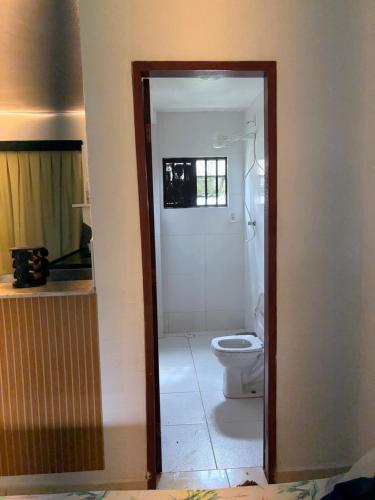 a bathroom with a white toilet and a door at Resort felicidade anexos in Extremóz