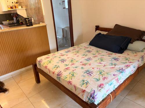 a bedroom with a bed with a floral comforter at Resort felicidade anexos in Extremóz