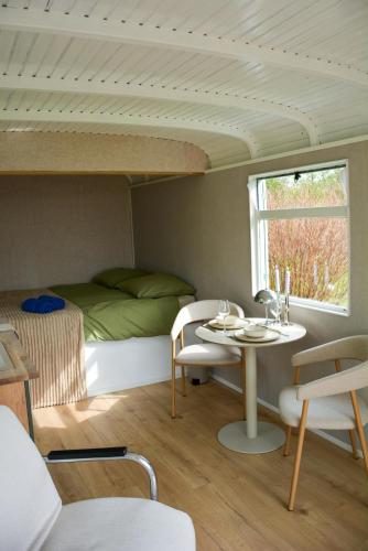 a room with a bed and a table and a bed at Bed & Bloemen in Niebert