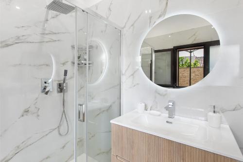 a white bathroom with a sink and a mirror at Perla Dell'Etna Holiday House in Zafferana Etnea