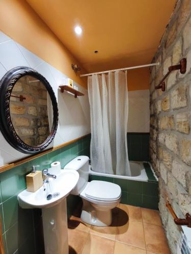 a bathroom with a toilet and a sink and a tub at Hotel Rural del Médico in Regumiel de la Sierra