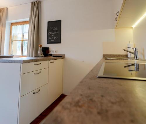 a kitchen with white cabinets and a counter top at Appartement Doris in Schröcken