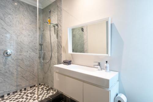 a white bathroom with a sink and a shower at Purple House Accommodations in Cape Town