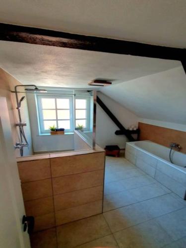 a bathroom with a bath tub and a window at Rheinhessen Auszeit in Wendelsheim