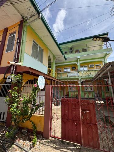 a house with a red gate in front of it at Medelaine's Beach Resort in Puerto Galera