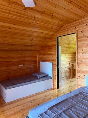 a bedroom with a bed in a wooden cabin at Cottage Sandro-Sandro in Kinkisha