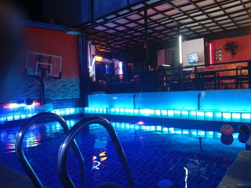 a swimming pool with blue lights in a room at BEN & LEK GUESTHOUSE in Pattaya South