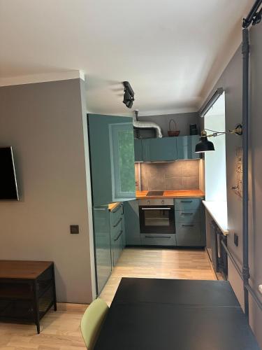 a small kitchen with blue cabinets and a table at City Center apartment in Jelgava in Jelgava