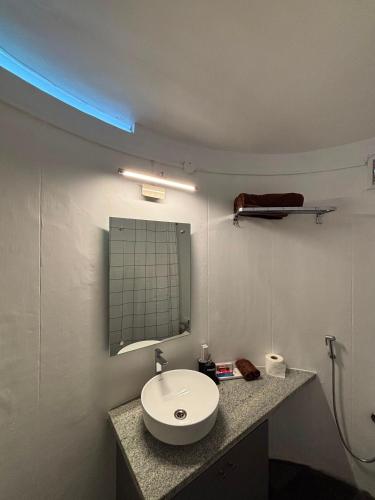 a bathroom with a white sink and a mirror at Trisara Boutique Stay in Mysore