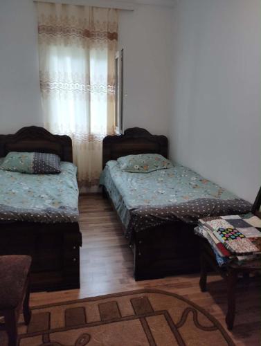 two twin beds in a room with a window at Natas Saxli in K'vemo Zhoshkha