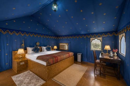 a bedroom with a king sized bed in a blue room at Marawi Desert Resort in Sām