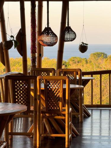 a porch with tables and chairs and lights at Penida Bambu Green Suites in Nusa Penida