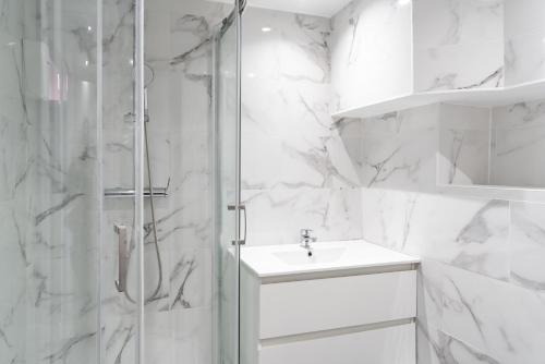 a white bathroom with a sink and a shower at Paris Hostel in Paris