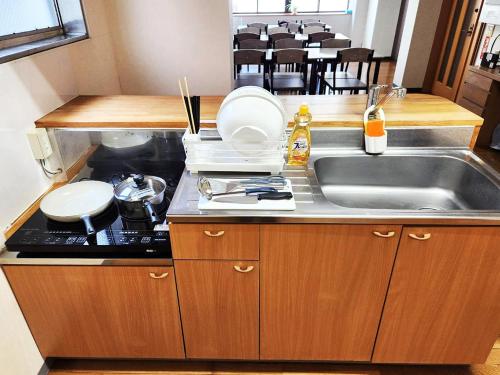 a kitchen with a sink and a counter top at ゲストハウス橋本旅館 肥後大津駅前 in Kikuyo