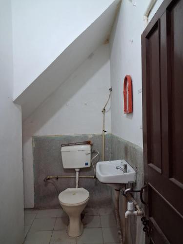 a bathroom with a toilet and a sink at Sandy Homestay in Dehradun
