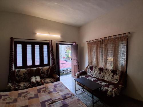 a bedroom with a bed and a chair and a window at Sandy Homestay in Dehradun