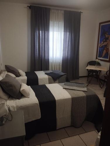 two beds sitting in a room with a window at Alice House in Arceto