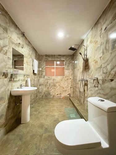 a bathroom with a toilet and a sink at Clavina Hotel in Gilgil