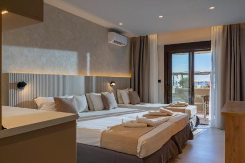 a hotel room with two beds and a balcony at Hotel Areti in Neos Marmaras