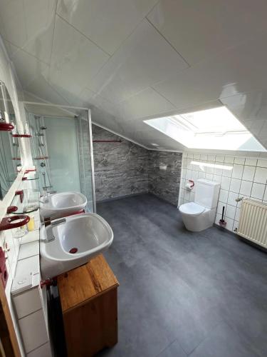 a bathroom with two sinks and a toilet at Gasthaus Trifelsblick in Wernersberg