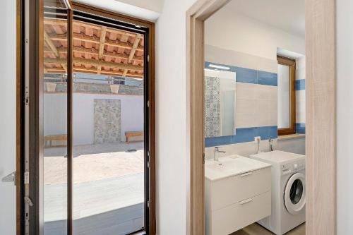 a bathroom with a sink and a washing machine at Mammina Holiday Home in Casal Velino