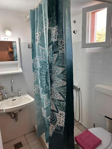a bathroom with a shower curtain and a sink at LYGIROS ANASTASIOS in Tarti