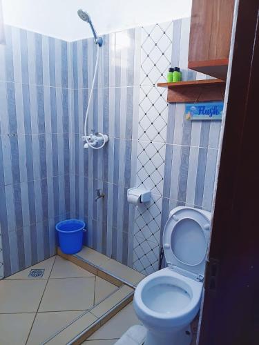 a bathroom with a shower and a toilet at Devkim Stays-Cozy Comfort Near The Beach in Ukunda