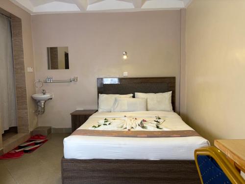 a bedroom with a bed with flowers on it at Clavina Hotel in Gilgil