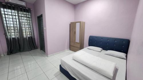 a bedroom with a bed with a blue headboard at Kelambu Beach Villa in Kudat