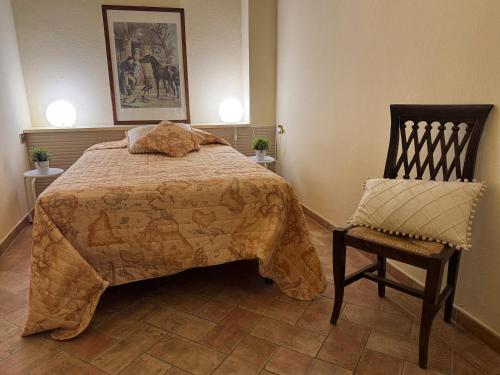 a bedroom with a large bed and a chair at Bartahouse in Peccioli