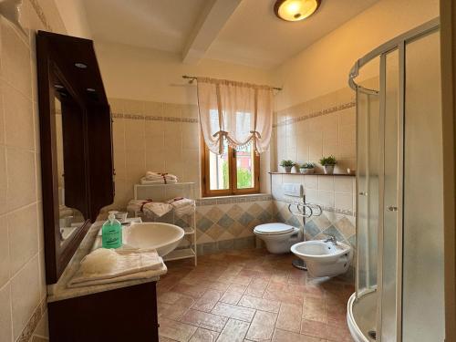 a bathroom with two sinks and a toilet and a window at Bartahouse in Peccioli