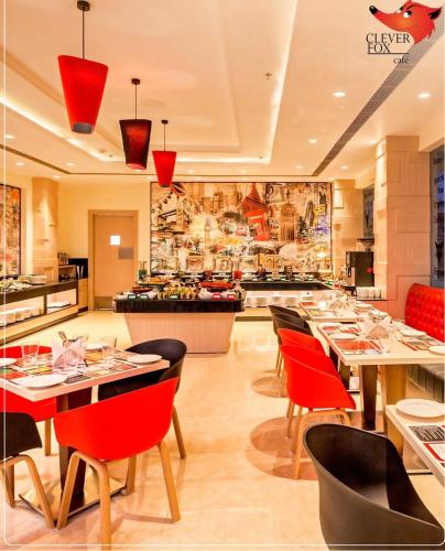 a restaurant with red chairs and tables in a room at Red Fox by Lemon Tree Hotels, Alwar in Alwar