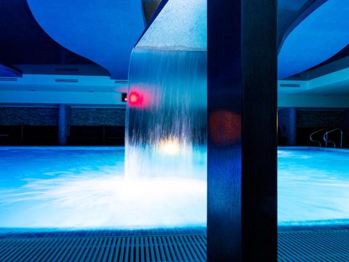 a water fountain in a pool with a red light at Ośrodek Delfin in Dąbki